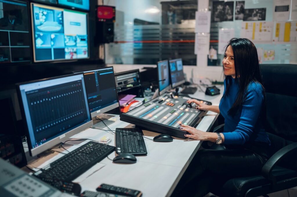 Middle aged woman using equipment in control room on a tv station